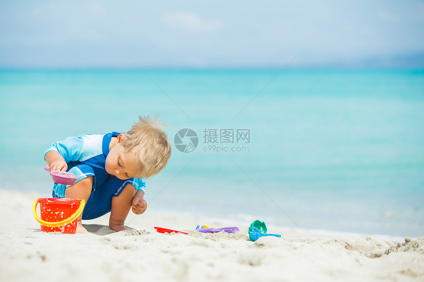 在热带海滩玩沙滩玩具的男孩白色情调男性儿童童年旅行异国假期海鱼天堂图片