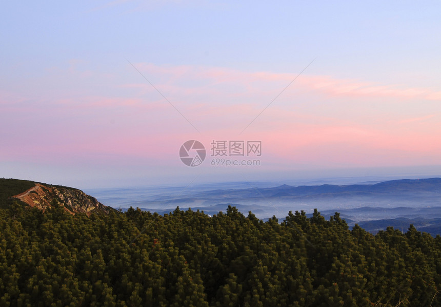 从山中升起山脉山峰森林日落远景树木粉色天空橙子图片