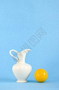 白色花瓶和黄色球背景图片