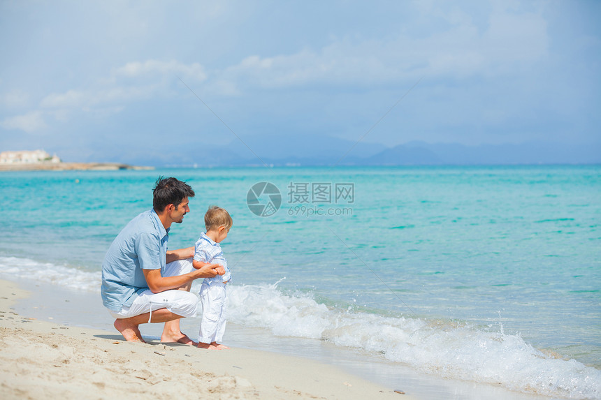 快乐的父亲和儿子在海滩玩耍天空家庭父母微笑男性假期孩子男生男人乐趣图片