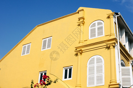 旧建筑的黄墙历史性白色装饰天空蓝色风格建筑学房子窗户背景图片