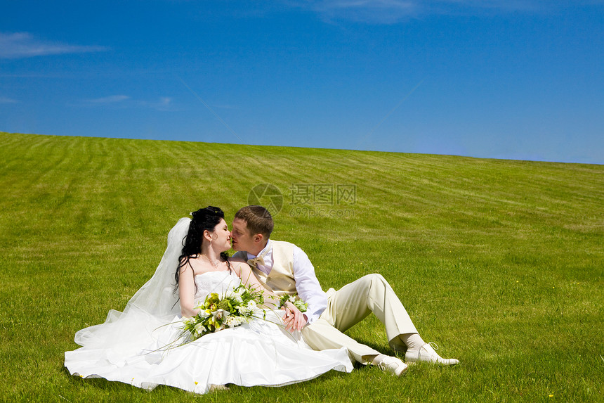 新婚夫妇在草地上的亲吻图片
