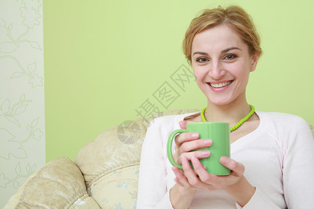 茶绿色项链快乐的女人咖啡杯子女性早餐休息指甲微笑幸福绿色背景