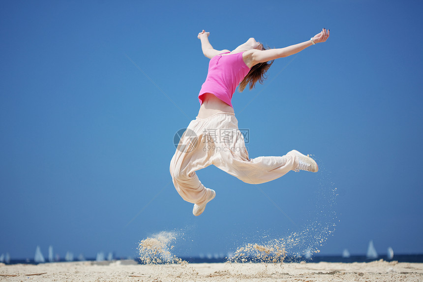 女孩在海滩上跳着跳着跳着游舞和跳着沙滩 夏季系列休息舞蹈家女性自由有氧运动跳跃舞蹈衣服霹雳舞街道图片