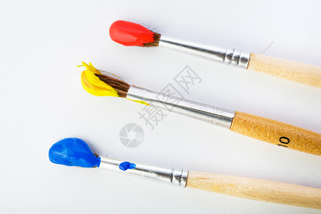 三个刷子工具红色染料油漆黄色蓝色画笔装潢艺术调色板背景图片
