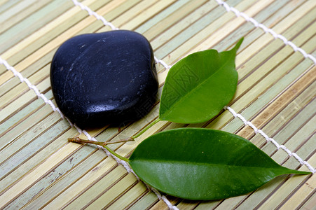 石头和树叶工作室文化健康岩石平衡治疗卵石植物药品黑色背景图片
