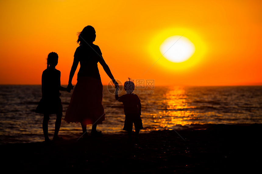 母亲和孩子的轮廓日落快乐阴影儿子女士海洋海滨妈妈女孩乐趣图片
