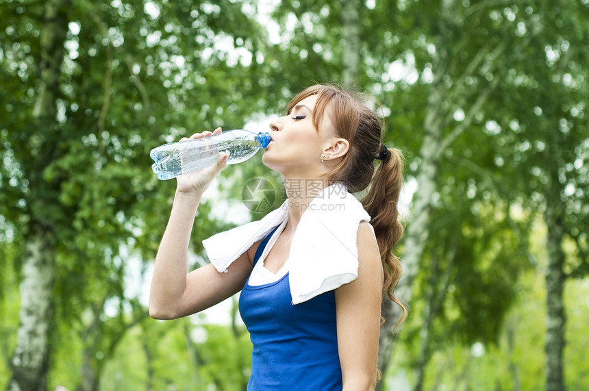 女青年在锻炼后饮用饮用水微笑口渴女孩女性女孩们减肥健身房饮食重量数字图片