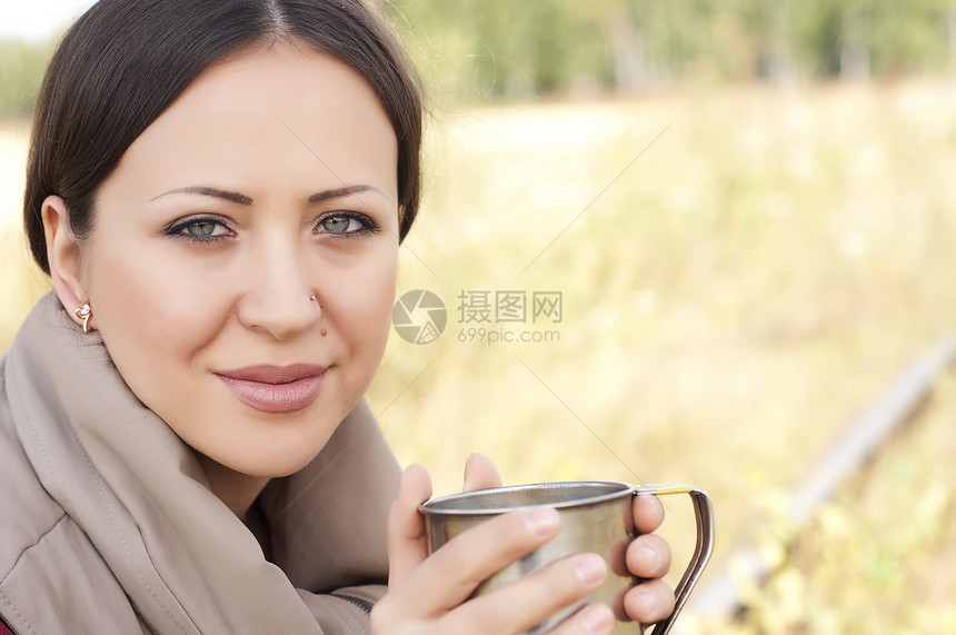 一个美丽的女孩的肖像 喝着一杯酒发型嘴唇杯子手指休息笑容眼睛游客图片