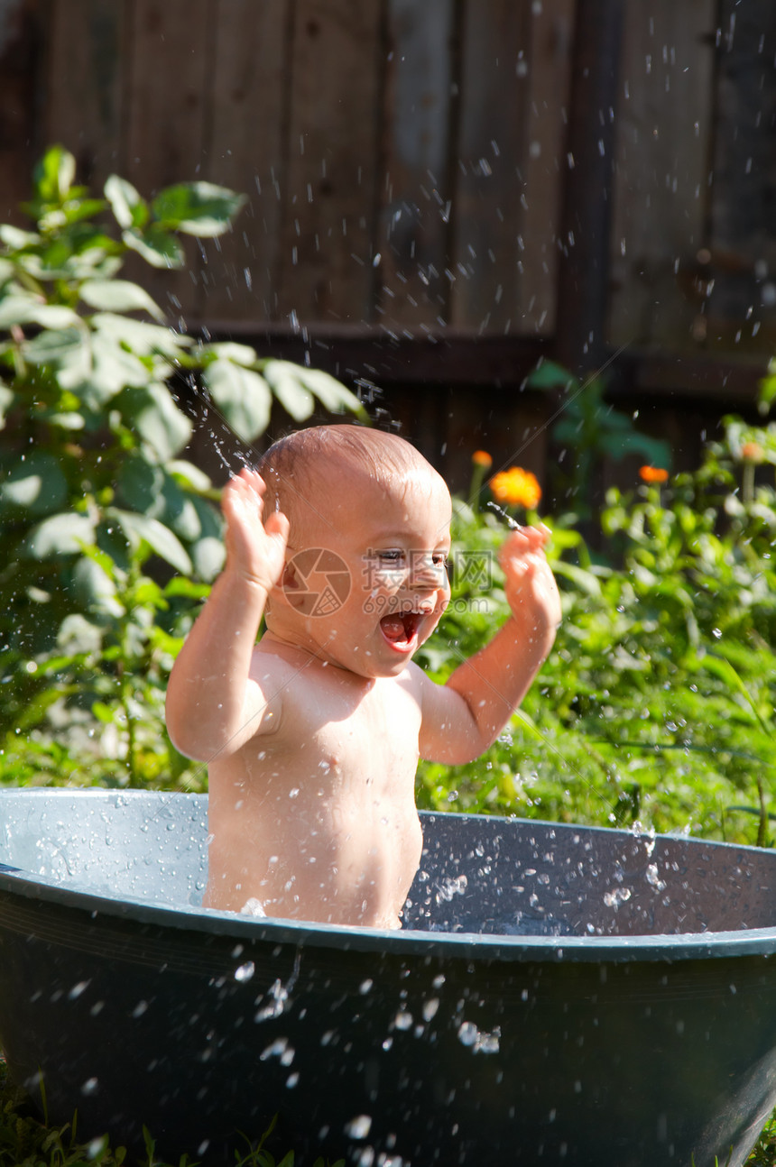 户外婴儿洗澡闲暇打扫洗涤浴缸儿子卫生飞溅后代享受微笑图片