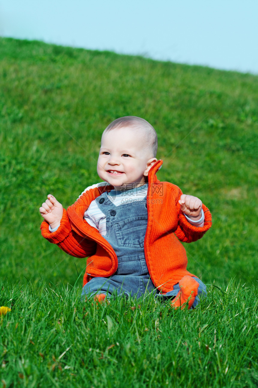 坐在绿草上微笑的婴儿后代孩子衣服幸福橙子快乐男孩们女孩男生头发图片