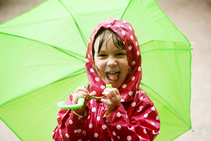 小女孩在雨中行走雨衣孩子雨滴育儿下雨微笑女孩红色水坑喜悦图片