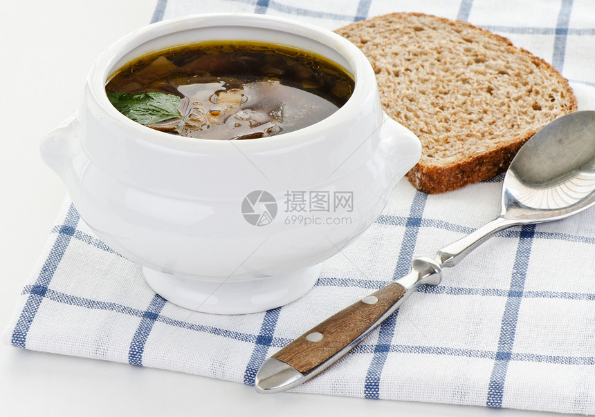 碗蘑菇汤 配汤匙和面包图片