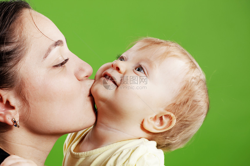母亲亲吻婴儿家庭孩子女儿乐趣绿色童年孩子们接吻情怀工作室图片