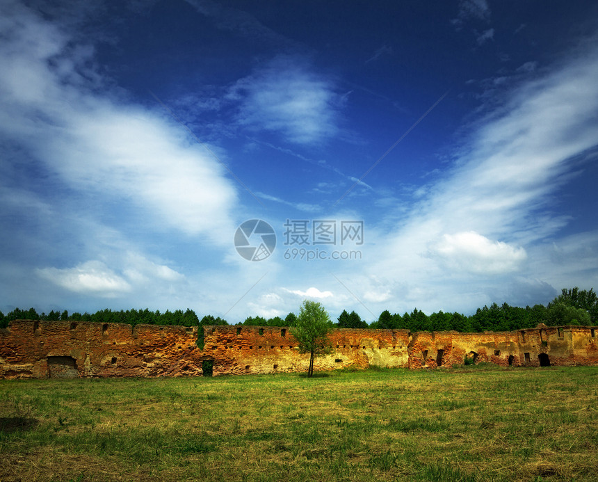 旧城堡的废墟黄色场地乡村蓝色工事草地石头晴天红色多云图片