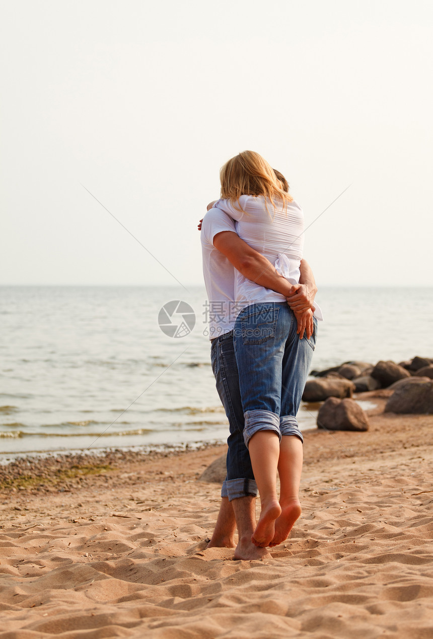 在海滩上玩一对情欢乐牛仔裤恋人微笑男人女士快乐成人海洋乐趣白色图片