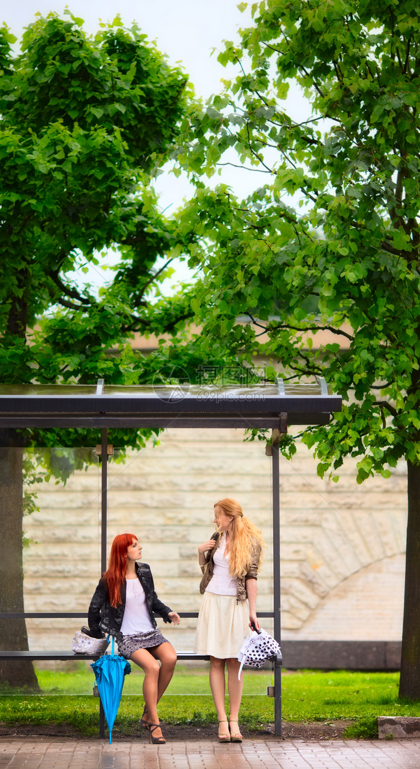 巴士站两个女孩街道旅行乘客城市讲话裙子运输卷曲座位会心图片