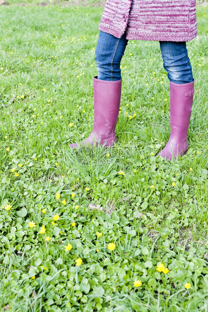 妇女穿着橡胶靴在春草草地上穿橡皮靴的情况毛衣裤子牛仔裤成人紫色女士外观女性鞋类牛仔布图片