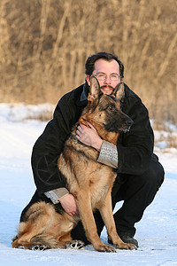 男人和狗坐着背景图片
