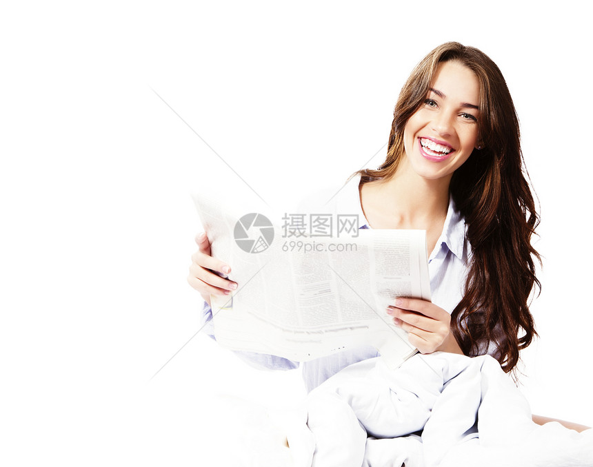 和报纸在床上的快乐女人图片