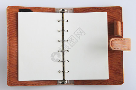 白色背景的皮革个人组织者笔记备忘录教育商业螺旋棕色床单笔记本空白日记背景图片