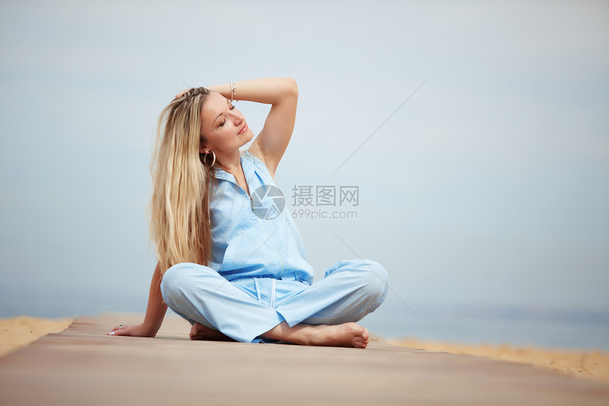 女人睡在沙滩上旅行头发蓝色喜悦快乐闲暇女性女士金发假期图片