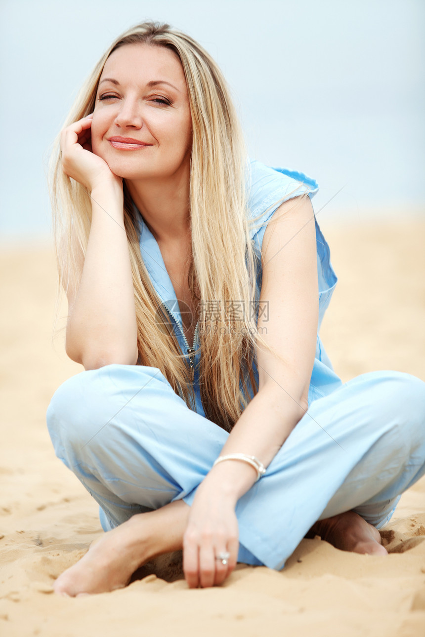 女人睡在沙滩上蓝色假期喜悦快乐金发头发海滩女性旅行休息图片