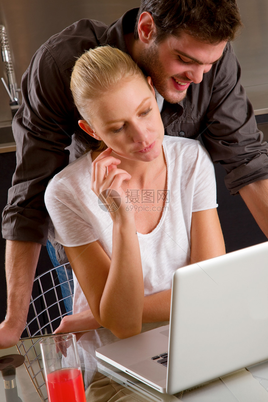 使用笔记本电脑的家庭妇女夫妇日常生活金发互联网两个人男人夫妻微笑长发玻璃饮料图片