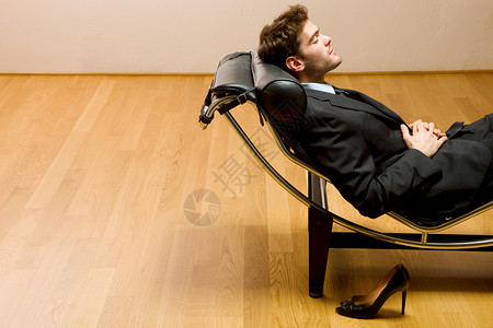 男人躺卧着在发光的长绳上职业装夹克领带说谎躺椅成人家具高跟鞋背景图片