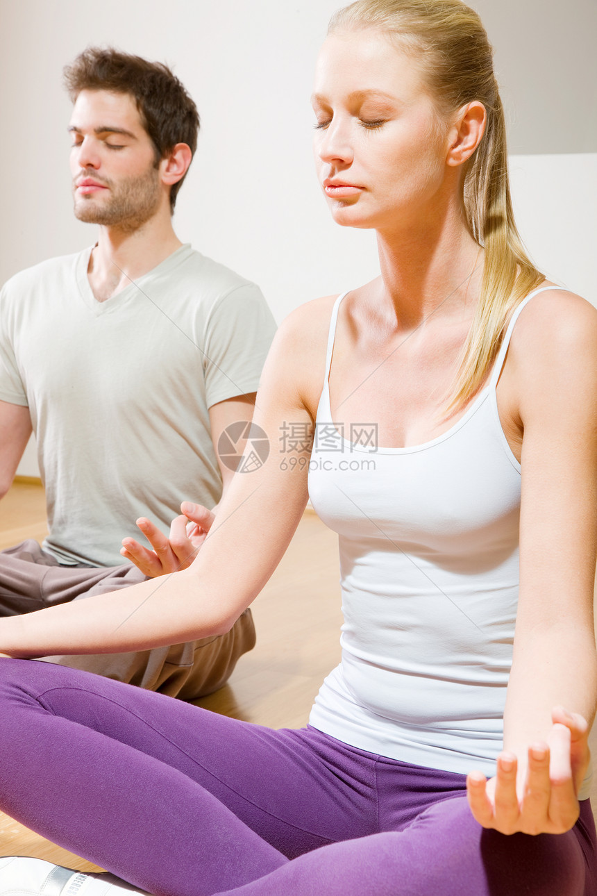 坐在地板上做瑜伽的情侣运动装女士背心眼睛成年人两个人长发夫妻头发按摩图片