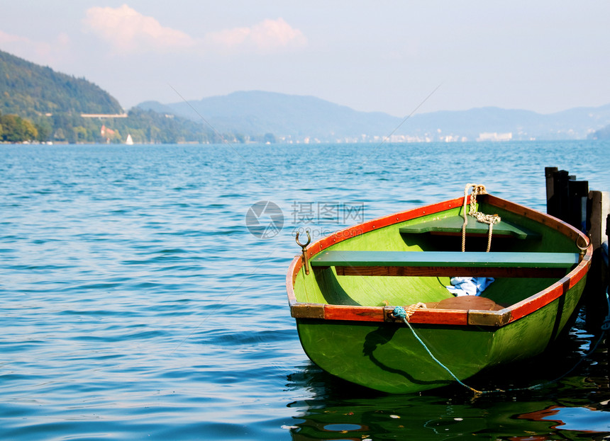 绿船在水上 背景是山丘图片