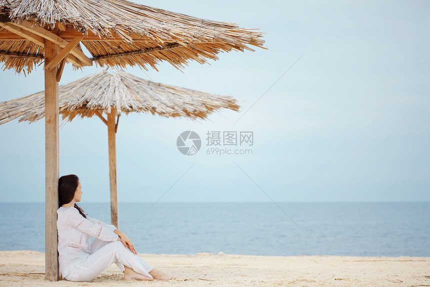 海滩上的女人休息蓝色旅行闲暇头发假期女孩热带天空冒充图片