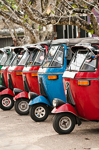 Tuktuk作为出租车 是一个受欢迎的亚洲人运输工具文化街道发动机三轮车车辆运输轮子城市冲程蓝色背景图片