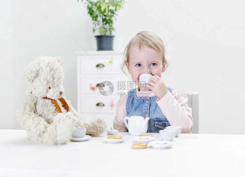 小孩用百吉饼喝茶茶壶孩子闲暇女孩乐趣杯子房间女性派对英语图片