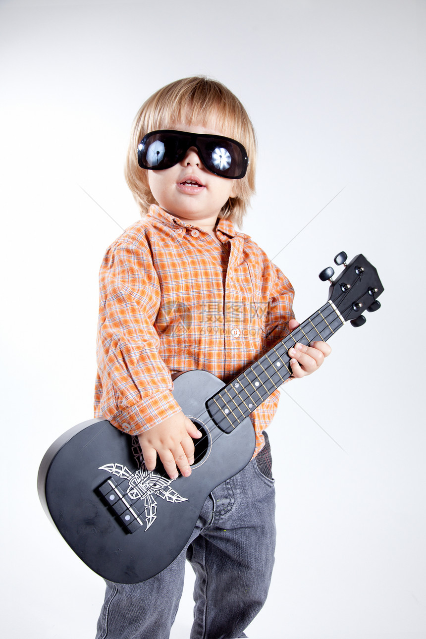 可爱的小男孩 配着乌鲁勒吉他太阳镜眼镜金发童年艺术婴儿裤子音乐音乐家教育图片