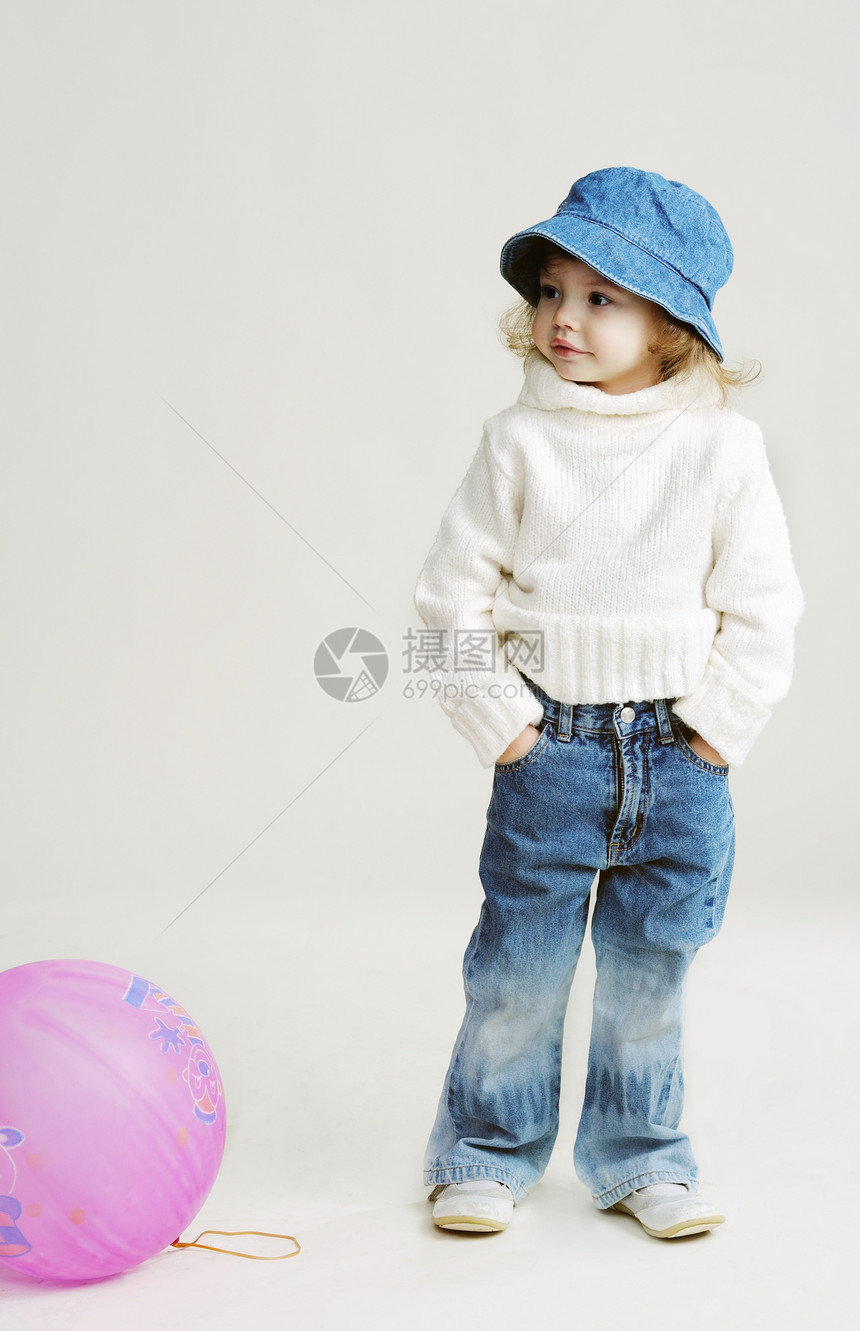 带气球的女孩毛衣童年闲暇白色地面牛仔裤帽子乐趣口袋蓝色图片
