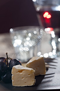 以葡萄酒和葡萄干酪黄色甜点传统玻璃盘子食物红色刀具黑色背景图片