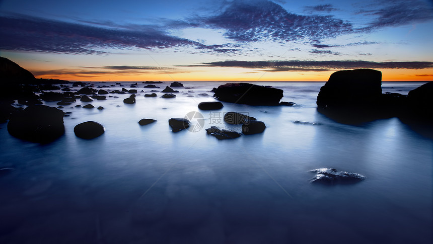平静海滩破坏海景岩石天空日落运动海岸海洋悬崖图片
