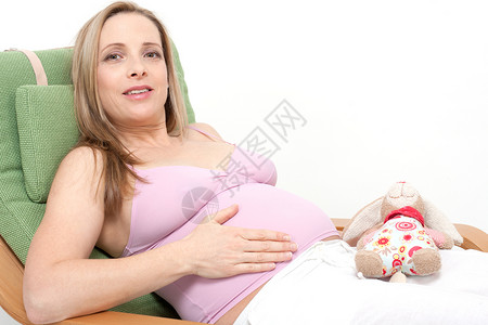 年老的孕妇盼望着她的宝宝母性父母妈妈成人分娩肚子女性母亲白色婴儿背景图片