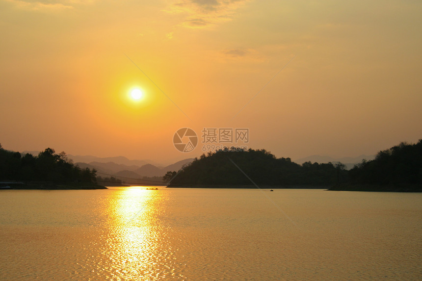 日落在泰国大坝上戏剧性反射涟漪地平线黄色美丽阳光荒野蓝色天空图片