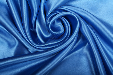平滑优雅的蓝色丝绸作为背景材料织物投标海浪银色天蓝色纺织品布料曲线折痕背景图片