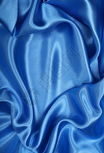 平滑优雅的蓝色丝绸作为背景银色纺织品曲线海浪天蓝色折痕织物投标布料材料背景图片