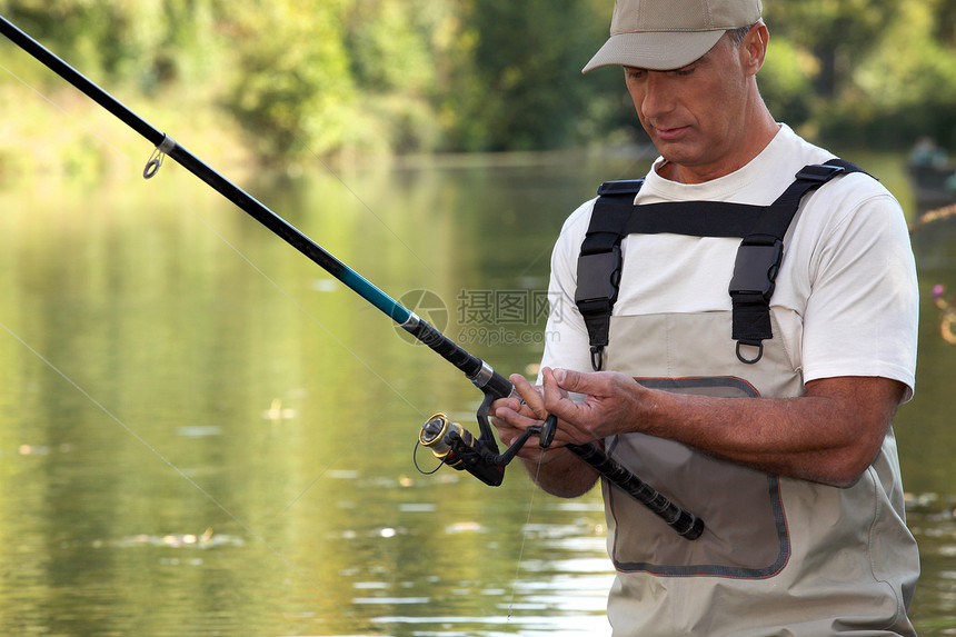 成年绅士在河中捕鱼图片