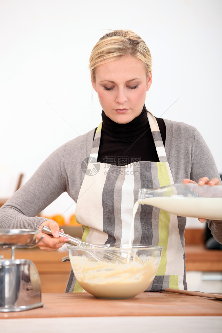 妇女在厨房里饮用混合混合物图片