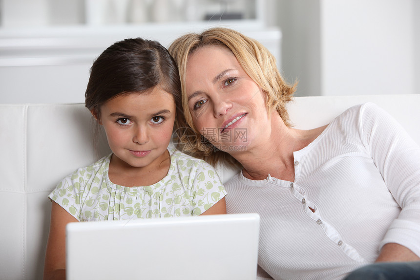 笔记本电脑上的母亲和女儿头发金发拥抱白色个人女士父母女性棕色微笑图片