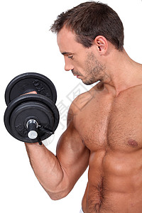 气势磅薄用哑铃锻炼身体的粗胸和肌肉人背景