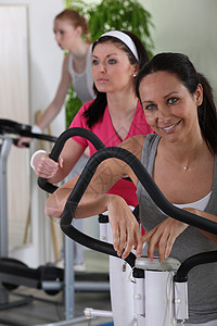 妇女在体育馆锻炼女性蒸腾工作福利眼线笔健身房出汗仪器跑步机微笑背景图片
