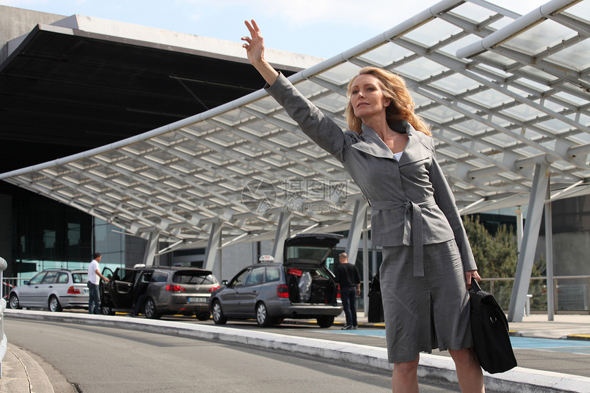 商业妇女挥舞出租车经理白色旅行金发工作飞机场套装女性女士管理人员图片