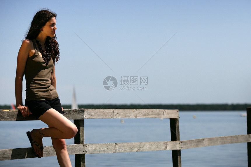 妇女独自站在码头上图片