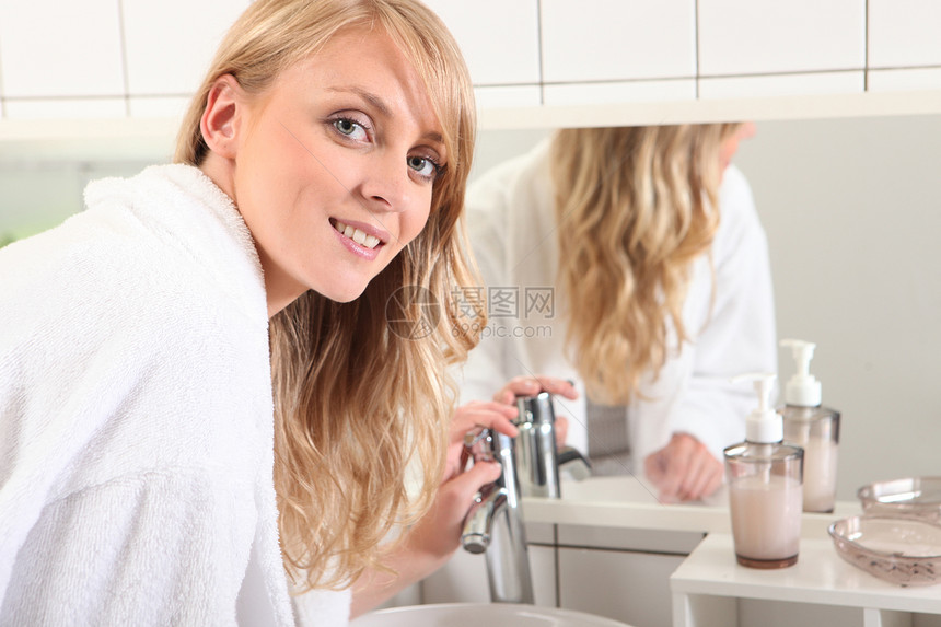 穿着浴袍的年轻金发女子 在浴室洗澡图片